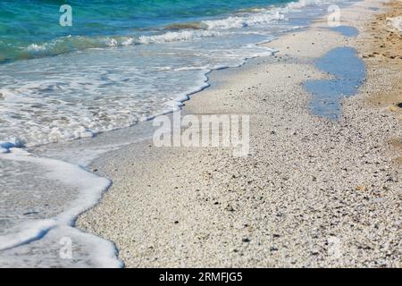 Blaues Wasser und viele weiße Körner auf dem Strand Arutas, bekannt als Reisstrand in Sardinien, Italien Stockfoto