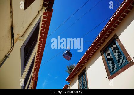 Seilbahnkabine über den Dächern von Gebäuden in Funchal, Madeira Insel, Portugal Stockfoto