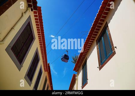 Seilbahnkabine über den Dächern von Gebäuden in Funchal, Madeira Insel, Portugal Stockfoto