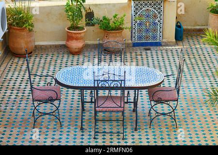 Wunderschönes und gemütliches marokkanisches Restaurant mit Tisch und Mosaiken in Fes, Marokko Stockfoto