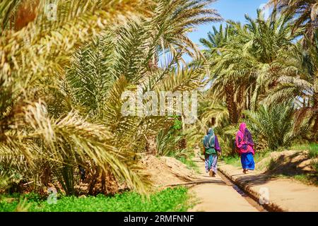 Zwei berberfrauen in Nationalkleidung, die in der Oase des Dorfes Merzouga in der Sahara, Marokko, spazieren Stockfoto