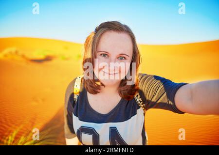 Glücklicher lächelnder Tourist, der Selfie mit Sanddünen in der Sahara nimmt, in Erg Chebby, Merzouga, Marokko Stockfoto