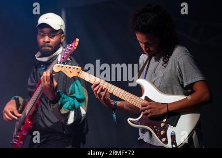 Simon Martinez spielt Gitarre mit Salami Rose Joe Louis beim Green man Festival in Wales, Großbritannien, August 2023. Foto: Rob Watkins Stockfoto