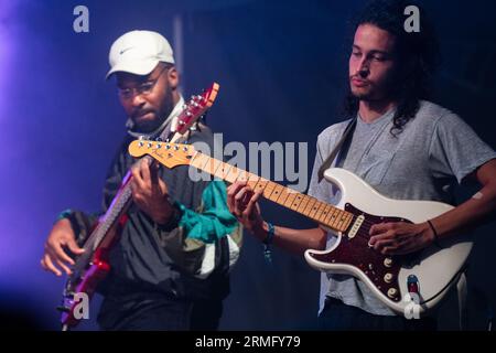 Simon Martinez spielt Gitarre mit Salami Rose Joe Louis beim Green man Festival in Wales, Großbritannien, August 2023. Foto: Rob Watkins Stockfoto