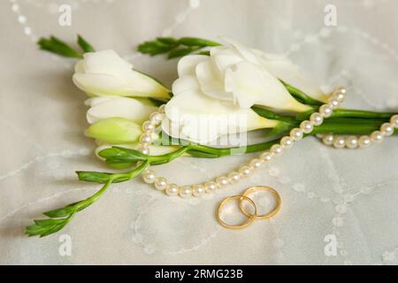Hochzeitskarte. Zwei goldene Ringe mit Brautschleier und Blumen Stockfoto