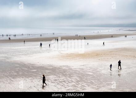 Filey Yorkshire viele Leute, die am Strand von Filey Beach Filey Bay im Meeresnebel Filey North Yorkshire UK GB Europe L S Lowry Stil spazieren gehen Stockfoto