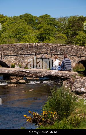 Im Sommer genießt man die Clapper Bridge über den East Dart River bei Postbridge im Dartmoor National Park in Devon, England, Großbritannien Stockfoto