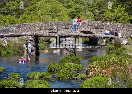 Im Sommer genießt man die Clapper Bridge über den East Dart River bei Postbridge im Dartmoor National Park in Devon, England, Großbritannien Stockfoto