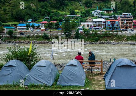 Keran Kupwara, Indien. 25. August 2023. Camping-Zelte sind am Ufer des Neelam River oder Kishan Ganga installiert, das Kaschmir in zwei Teile geteilt hat, die von den Atomrivalen Indien und Pakistan kontrolliert werden. Der Fluss fungiert als umstrittene Kontrolllinie und fließt von beiden Seiten durch ein Dorf namens Keran, das sich auf der Nordseite des indischen Kaschmirgrenzbezirks Kupwara befindet, etwa 150 km von Srinagar und 93 km von Muzaffarabad entfernt, auf der pakistanischen Seite von Kaschmir. (Foto: Faisal Bashir/SOPA Images/SIPA USA) Credit: SIPA USA/Alamy Live News Stockfoto