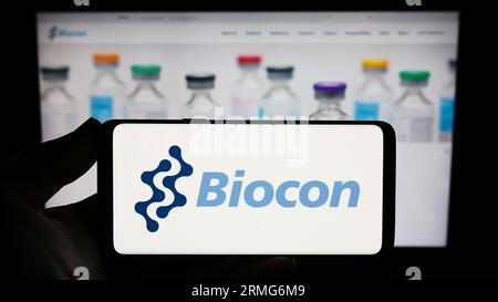 Person, die ein Smartphone mit dem Logo des indischen biopharmazeutischen Unternehmens Biocon Limited auf dem Bildschirm vor der Website hält. Konzentrieren Sie sich auf das Display des Telefons. Stockfoto