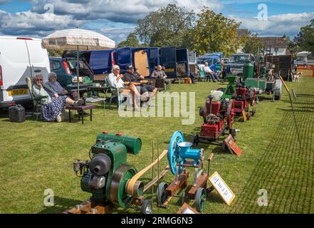 Klassische stationäre Motorenliebhaber sitzen und zeigen ihre Maschinen auf einem Dorffest in Wisborough Green, West Sussex, Großbritannien. Stockfoto