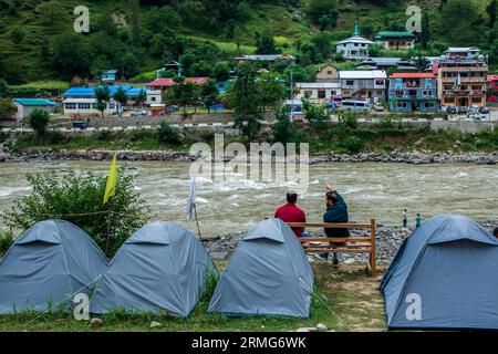 Camping-Zelte sind am Ufer des Neelam River oder Kishan Ganga installiert, das Kaschmir in zwei Teile geteilt hat, die von den Atomrivalen Indien und Pakistan kontrolliert werden. Der Fluss fungiert als umstrittene Kontrolllinie und fließt von beiden Seiten durch ein Dorf namens Keran, das sich auf der Nordseite des indischen Kaschmirgrenzbezirks Kupwara befindet, etwa 150 km von Srinagar und 93 km von Muzaffarabad entfernt, auf der pakistanischen Seite von Kaschmir. Stockfoto