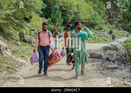 24. August 2023: Keran Kupwara, Jammu und Kaschmir, Indien: Die Menschen in Indien verwalteten Kaschmir gehen zusammen mit Lebensmitteln und Decken, während sie sich auf das Camping am Ufer des Neelam River oder Kishan Ganga vorbereiten, das Kaschmir in zwei Teile geteilt hat, die von den Atomrivalen Indien und Pakistan kontrolliert werden. Der Fluss fungiert als umstrittene Kontrolllinie und fließt von beiden Seiten durch ein Dorf namens Keran, das sich auf der Nordseite des indischen Kaschmirgrenzbezirks Kupwara befindet, etwa 150 km von Srinagar und 93 km von Muzaffarabad entfernt, auf der pakistanischen Seite von Kaschmir. (Bild: © Faisal Bashir Stockfoto