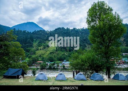 Am 25. August 2023, Keran Kupwara, Jammu und Kaschmir, Indien: Zelte werden am Ufer des Neelam River oder Kishan Ganga installiert, der Kaschmir in zwei Teile geteilt hat, die von den Atomrivalen Indien und Pakistan kontrolliert werden. Der Fluss fungiert als umstrittene Kontrolllinie und fließt von beiden Seiten durch ein Dorf namens Keran, das sich auf der Nordseite des indischen Kaschmirgrenzbezirks Kupwara befindet, etwa 150 km von Srinagar und 93 km von Muzaffarabad entfernt, auf der pakistanischen Seite von Kaschmir. (Bild: © Faisal Bashir/SOPA Images via ZUMA Press Wire) NUR REDAKTIONELLE VERWENDUNG! Nicht für kommerzielle USA Stockfoto