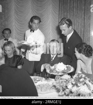 Laurel und Hardy waren ein britisch-amerikanisches Comedy-Duo während der frühen klassischen Hollywood-Ära des amerikanischen Kinos, bestehend aus dem Engländer Stan Laurel (1890–1965) und dem Amerikaner Oliver Hardy (1892–1957). Stan Laurel ist auf einer Dinnerparty in Stockholm 1947 abgebildet. Kristoffersson ref AE14-9 Stockfoto