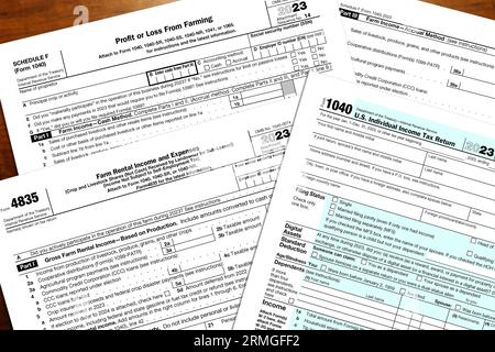 2023 IRS 1040-Formular und Formulare für die Landwirtschaftssteuer auf einem Schreibtisch. Stockfoto