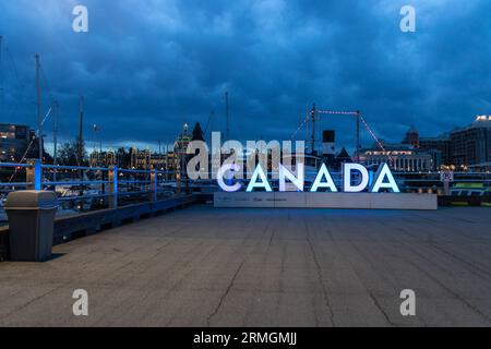 Victoria, KANADA - 4. Januar 2023 : berühmtes KANADISCHES Schild im Victoria Harbor am Abend. Stockfoto