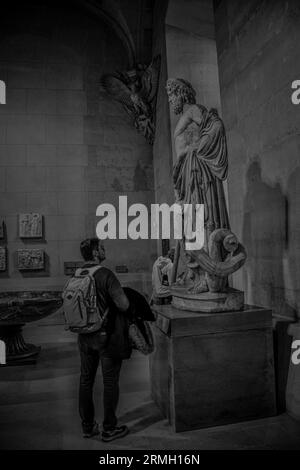 Ein Junge in einem Museum, der eine Statue betrachtet Stockfoto