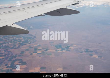 Blick vom Flugzeug aus auf Farmland darunter, einschließlich Bewässerung in der Mitte der Pivot im westlichen Teil der Vereinigten Staaten. Stockfoto