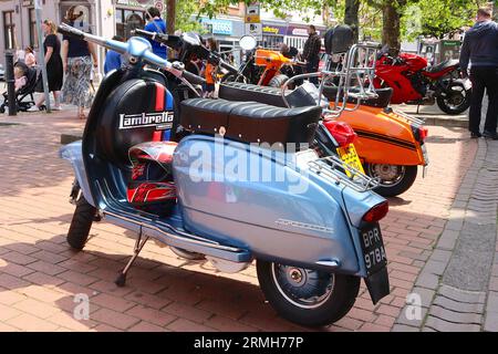 2003 die schwarze Vespa PX125 wurde während einer italienischen Fahrzeugshow im Mai 2023 zwischen einer blauen 1963 Lambretta Li125 und einer orangefarbenen 1969 Lambretta GP200 platziert. Stockfoto