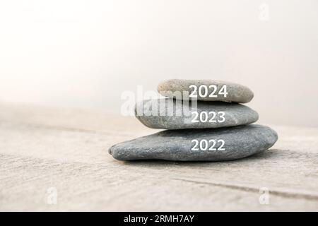 Frohes neues Jahr, 2024 ersetzt altes 2023. Das neue Jahr 2024 steht vor der Konzeptidee am Strand. Kreatives Foto kann als Display, gedruckte Leinwand oder Web verwendet werden Stockfoto