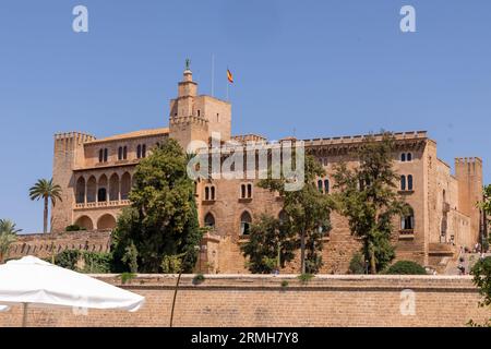 Weite Aufnahme des königlichen Palastes der Almudaina auf Mallorca an einem sonnigen Tag Qith weiße Sonnenschirme im Vordergrund Stockfoto