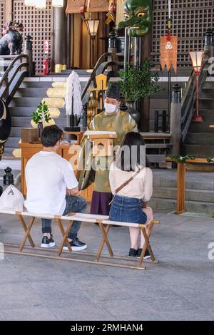 Japan, Kyushu, Fukuoka, Hakata. Kushida Shinto-Schrein-Priester leitet Zeremonie für Gläubige. Stockfoto