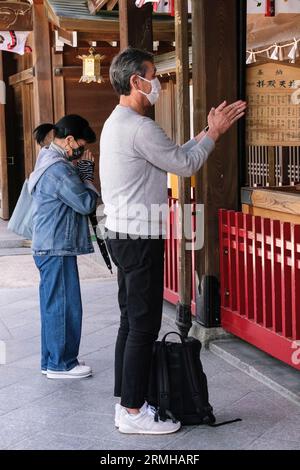 Japan, Kyushu, Fukuoka, Hakata. Der Anbeter Clapping soll seine Präsentation im Kushida Shinto-Schrein ankündigen Stockfoto