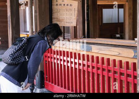 Japan, Kyushu, Fukuoka, Hakata. Verehrer verbeugt sich am Kushida Shinto-Schrein Stockfoto