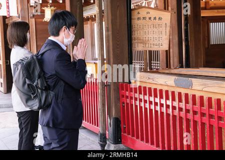 Japan, Kyushu, Fukuoka, Hakata. Anbeter betet im Kushida Shinto-Schrein Stockfoto