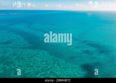 Wolkenschatten, verschiedene Wassertiefen und Korallenriffe schaffen verschiedene Blautöne auf dem Ozean vor der Küste von Belize Stockfoto