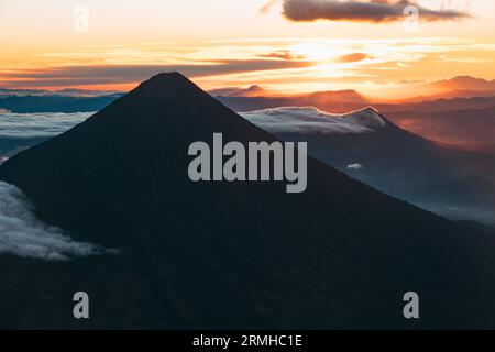 Die Sonne geht hinter dem Vulkan Agua in Guatemala auf und verleiht eine dramatische Silhouette Stockfoto