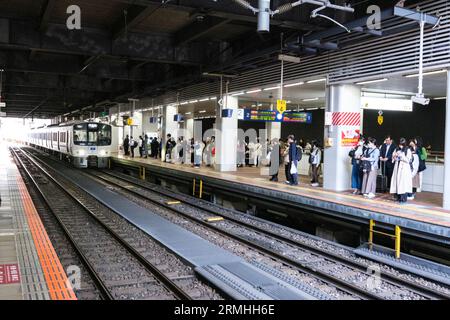 Japan, Fukuoka. Passagiere des Bahnhofs Hakata, die auf den Zug warten. Stockfoto