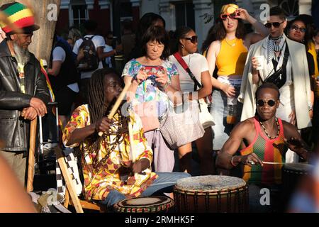 Männer trommeln energisch auf der Portobello Road während des Notting Hill Karnevals zur karibischen Kultur. 28/08/2023 Stockfoto