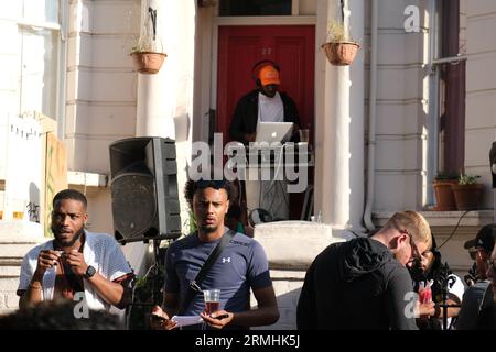 Der Mann spielt Musik von seinem Computer vor der Tür eines Hauses während der jährlichen Karnevalsfeier der Karibik. 28/08/2023 Stockfoto