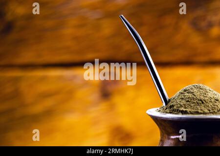 Gaucho Yerba Mate Tee, der chimarão, typisch brasilianisches Getränk, traditionell in einer Cuiade Bombilla Stick Kürbis vor Holzgrund. Rio Grande do Stockfoto