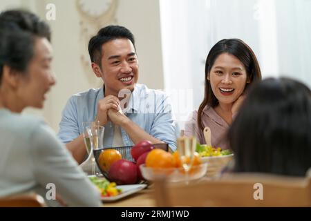 Mehrere Generationen asiatischer Familien unterhalten sich, während sie zu Hause zusammen essen Stockfoto