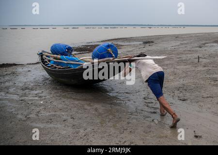 Khulna, Bangladesch. 26. August 2023. Ein Fischer wird auf dem Fluss Shibsha zum Angeln gesehen. Fischerei und Krabbenfang sind die Haupteinnahmequellen in Kalabogi in Khulna, Bangladesch. Vor nicht allzu langer Zeit war Kalabogi, ein Küstendorf in Bangladesch, voll von kultivierbarem Land, bis der Anstieg des Meeresspiegels begann, das Gebiet bis zur Bucht von Bengalen zu verschlingen. Häufige Zyklone und Überschwemmungen haben das Dorf seit den späten 1990er Jahren getroffen 2009 zerstörte ein großer Zyklon namens Aila die 1.400 Kilometer Dämme, 8.800 Kilometer Straßen und etwa 50.000 Hektar Ackerland. Stockfoto