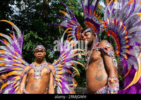 Männliche Teilnehmer an der Notting Hill Carnival Grand Parade 2023, London, UK. In farbenfrohen, aufwendigen Federkostümen Stockfoto