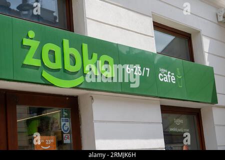 Schild des polnischen Lebensmittelgeschäfts ZABKA Cafe. Supermarkt mit grünem Schild. Hausfassade. Straßengeschäft. Warschau, Polen - 26. Juli 2023. Stockfoto