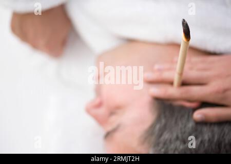 Nahaufnahme von Männerkopf mit Ohrkerze Stockfoto