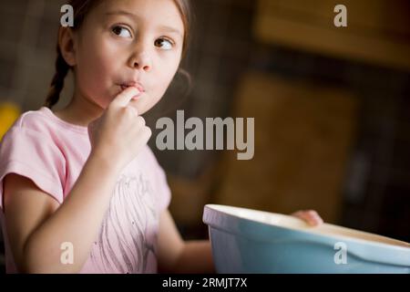 Junge, die sich den Finger leckt Stockfoto