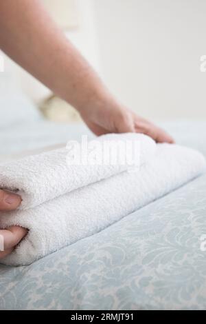 Nahaufnahme von Mannhände anpassen Handtuch auf Bett Stockfoto
