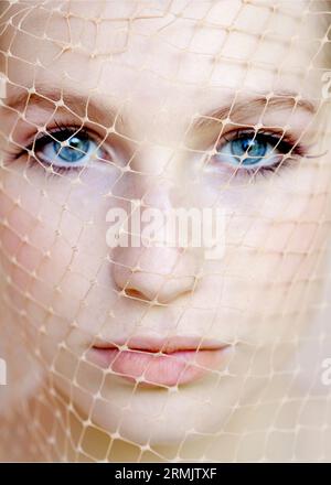 Extreme Nahaufnahme einer jungen schönen Frau, die ein Netz im Gesicht trägt Stockfoto