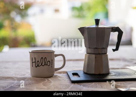 Kaffeetasse mit der Botschaft „Hallo“ und „Vintage Coffee Maker“. Stockfoto