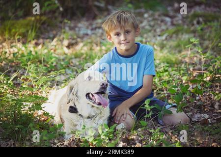 Ornhoj, Dänemark, 4. Juli 2023: Junge, der den Hund im Wald führt Stockfoto