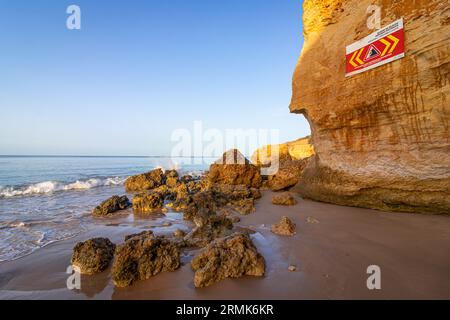 FELSSTURZ INSTABILE KLIPPEN, HALTEN SIE Einen SICHEREN ABSTAND ist in englischer Sprache auf einem Warnschild in Portugal auf den Klippen des Atlantischen Ozeans geschrieben. Felsen und Stockfoto