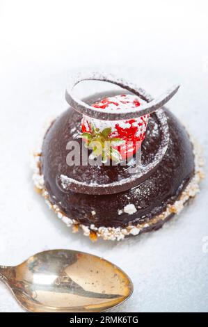 Frischer Schokoladen-Erdbeermousse über weiß mit Silberlöffel Stockfoto