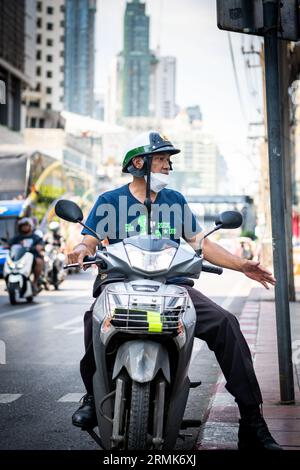 Ein thailändischer Mann hält an der Phetchaburi Rd Bangkok, Thailand auf seinem Motorrad, mit einem Helm im Polizeistil. Stockfoto