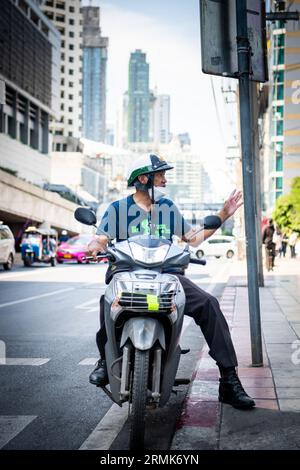 Ein thailändischer Mann hält an der Phetchaburi Rd Bangkok, Thailand auf seinem Motorrad, mit einem Helm im Polizeistil. Stockfoto